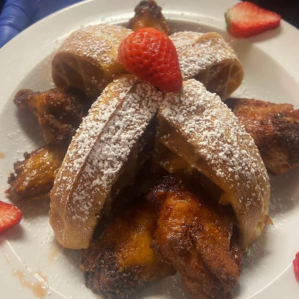 Chef Reeky's Cafe & Juice Bar's chicken and waffles, dusted with powdered sugar and garnished with strawberries.